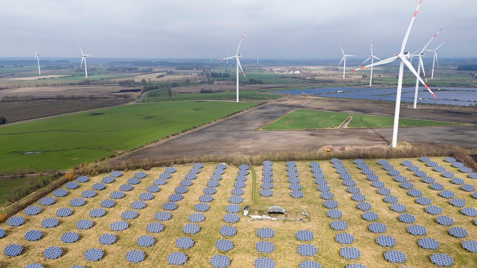 Paneles solares al borde de un parque eólico en Sprakebuell, Alemania.