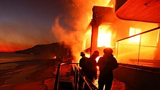 Пожарные работают с палубы, пока пожар в Палисейдс горит на пляже в среду, 8 января 2025 года, в Малибу, Калифорния.