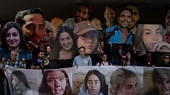 Gazze'de Hamas tarafından alıkonulan İsrailli rehinelerin yakınları ve destekçileri, Çarşamba günü İsrail'in Tel Aviv kentinde rehinelerin geri dönmesi için düzenlenen bir protesto sırasında sevdiklerinin fotoğraflarını tutuyor.