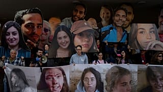 Familiares e apoiantes dos reféns israelitas detidos pelo Hamas em Gaza seguram fotografias dos seus entes queridos durante um protesto que apela ao seu regresso, em Telavive, Israel, na quarta-feira.