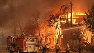 رجال الإطفاء يخدمون مبنى يحترق في جادة ليك أفينيو، الأربعاء، 8 يناير 2025، في وسط مدينة ألتادينا في باسادينا، كاليفورنيا.