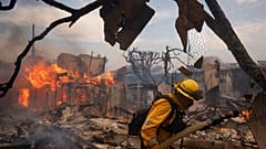 Strażak walczy z pożarem w dzielnicy Pacific Palisades w Los Angeles