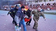 Фотография предоставлена Запорожской областной военной администрацией 8 января 2025 года, люди переносят раненую женщину на носилках в машину скорой помощи после росси