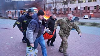 Фотография предоставлена Запорожской областной военной администрацией 8 января 2025 года, люди переносят раненую женщину на носилках в машину скорой помощи после росси