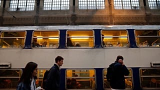 Paris'teki Gare de Lyon tren istasyonunda yolcular bir trenin yanından geçiyor, 2018