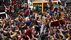 Bei seiner jährlichen Prozession in Manila, Philippinen, klettern die Gläubigen auf den Wagen, der die Statue von Jesus Nazareno trägt, 09.01.2025