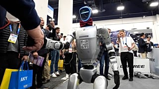 Um robô Unitree H1 aperta a mão de um participante na feira de tecnologia CES em Las Vegas, 08.01.2025