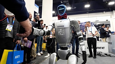 Bir Unitree H1 robotu Las Vegas'taki CES teknoloji fuarında bir katılımcıyla el sıkışıyor, 08.01.2025