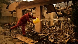 Shane Torre éteint les points chauds de ce qui reste de sa maison à Altadena, en Californie, le 09.01.2025