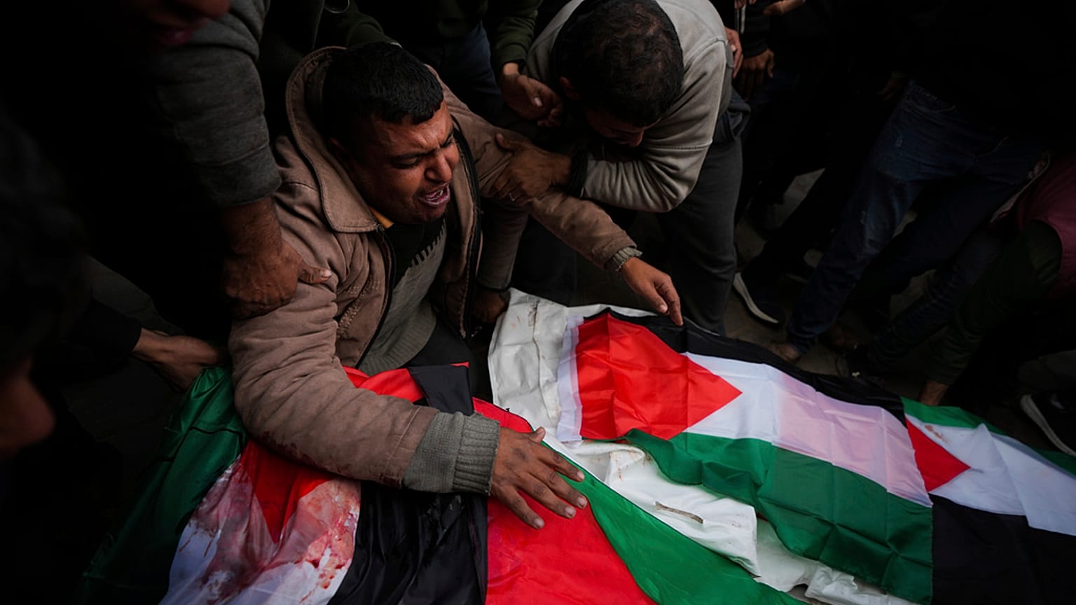 فلسطينيون ينعون أقاربهم الذين قتلوا في القصف الإسرائيلي لقطاع غزة، في مستشفى شهداء الأقصى في دير البلح، الأحد، 5 يناير، 2025. 