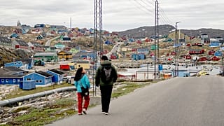 Emberek sétálnak a nyugat-grönlandi Aasiaat városában, amely a névadó szigetén, a grönlandi Aasiaat-szigetcsoport szívében található, 2024. június 29-én, szombaton. 