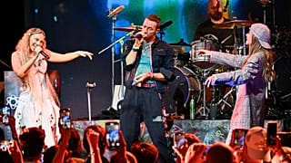 Elyanna, left, and TINI, right, perform with Chris Martin, second from left, and Will Champion of Coldplay on Monday, Oct. 7, 2024
