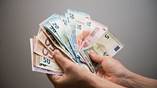 Una persona con varios billetes de euro en la mano