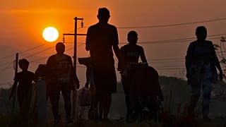 Migrantes caminham ao nascer do sol ao longo de uma autoestrada no sul do México em direção à fronteira com os EUA, 8 de janeiro de 2024