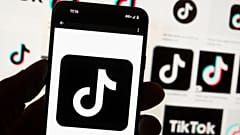 TikTok logosu Boston'da bir bilgisayar ekranı önünde bir cep telefonunda görüntüleniyor, 14 Ekim, 2022