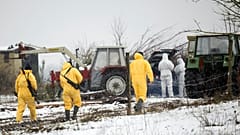 Bewaffnete Beamte in Schutzkleidung gehen durch einen Bauernhof in Hoppegarten, 10. Januar 2025. (Sebastian Gollnow/dpa via AP)