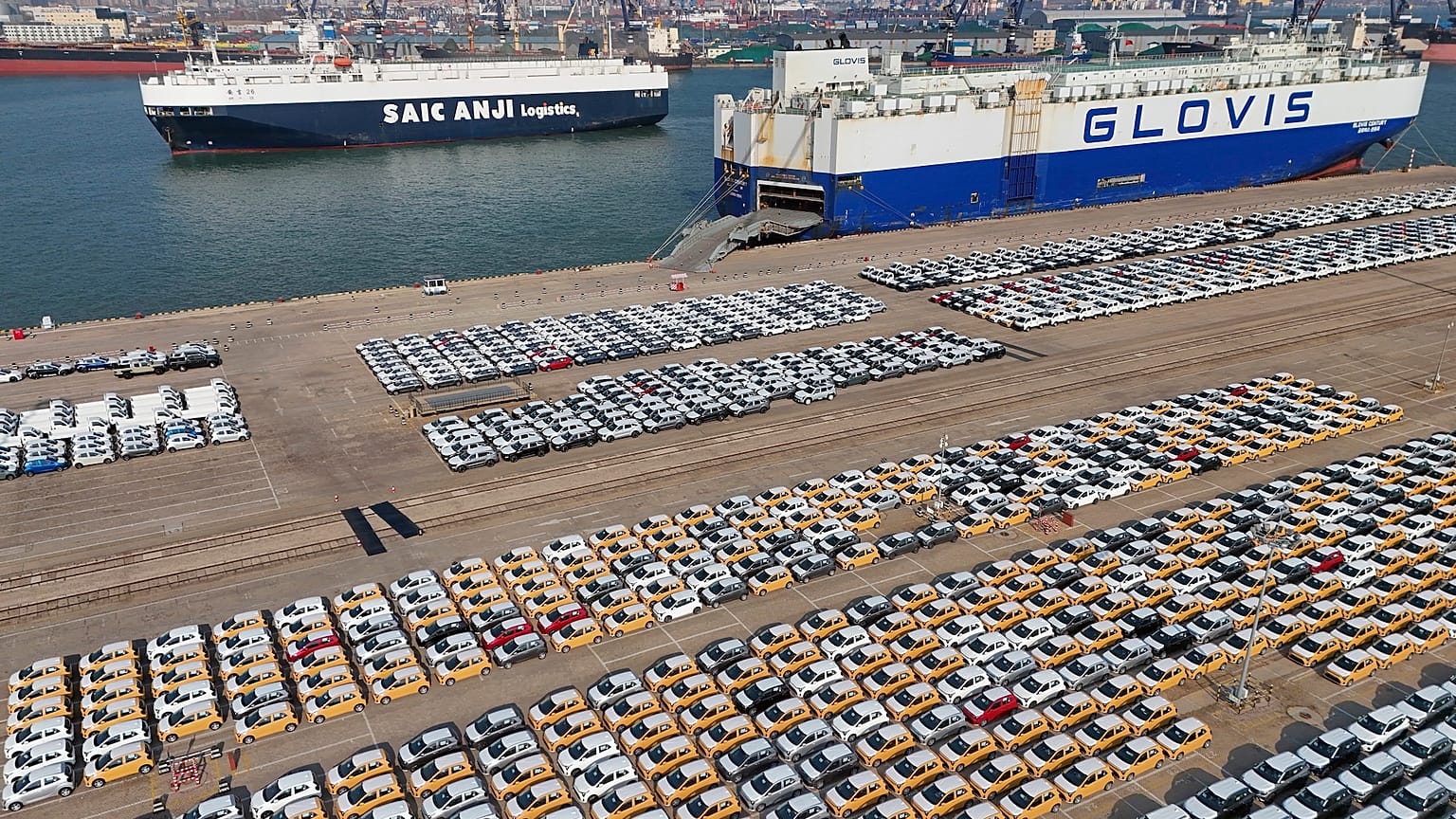 Veículos e camiões para exportação aguardam transporte num porto em Yantai, na província de Shandong, no leste da China