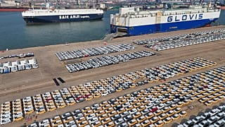 Veículos e camiões para exportação aguardam transporte num porto em Yantai, na província de Shandong, no leste da China