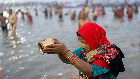 A Hindu devotee prays before taking a dip at the confluence of the Ganges, the Yamuna and the mythical Saraswati rivers on the first day of the 45-day-long Maha Kumbh festival