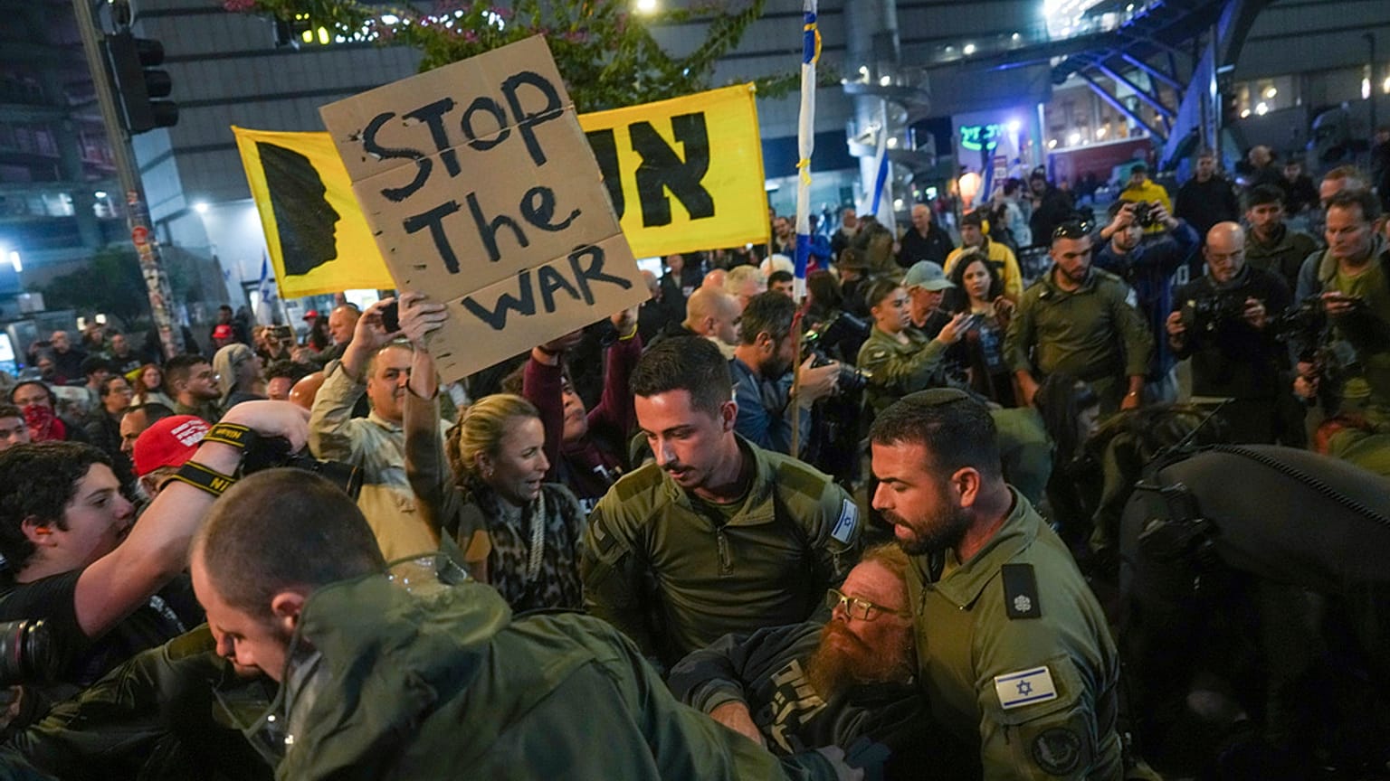 Police scuffle with demonstrators who block a road during a protest demanding a cease-fire deal and the immediate release of hostages held in the Gaza Strip by Hamas