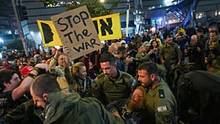 Police scuffle with demonstrators who block a road during a protest demanding a cease-fire deal and the immediate release of hostages held in the Gaza Strip by Hamas