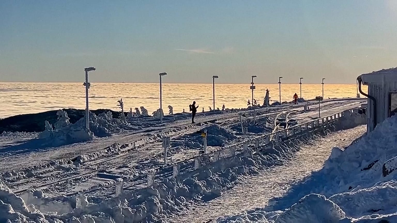 Wanderer genießen den frühen Morgenspaziergang in der verschneiten Landschaft des Harzes in Norddeutschland
