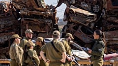 İsrail'in güneyindeki Netivot kasabasında askerler, 7 Ekim 2023'te, Hamas'ın sızma girişimi sırasında yakılan araçların yanında, 13 Ocak 2025