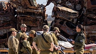 İsrail'in güneyindeki Netivot kasabasında askerler, 7 Ekim 2023'te, Hamas'ın sızma girişimi sırasında yakılan araçların yanında, 13 Ocak 2025