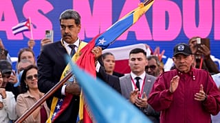 Nicolás Maduro sujetando una bandera venezolana junto a Daniel Ortega
