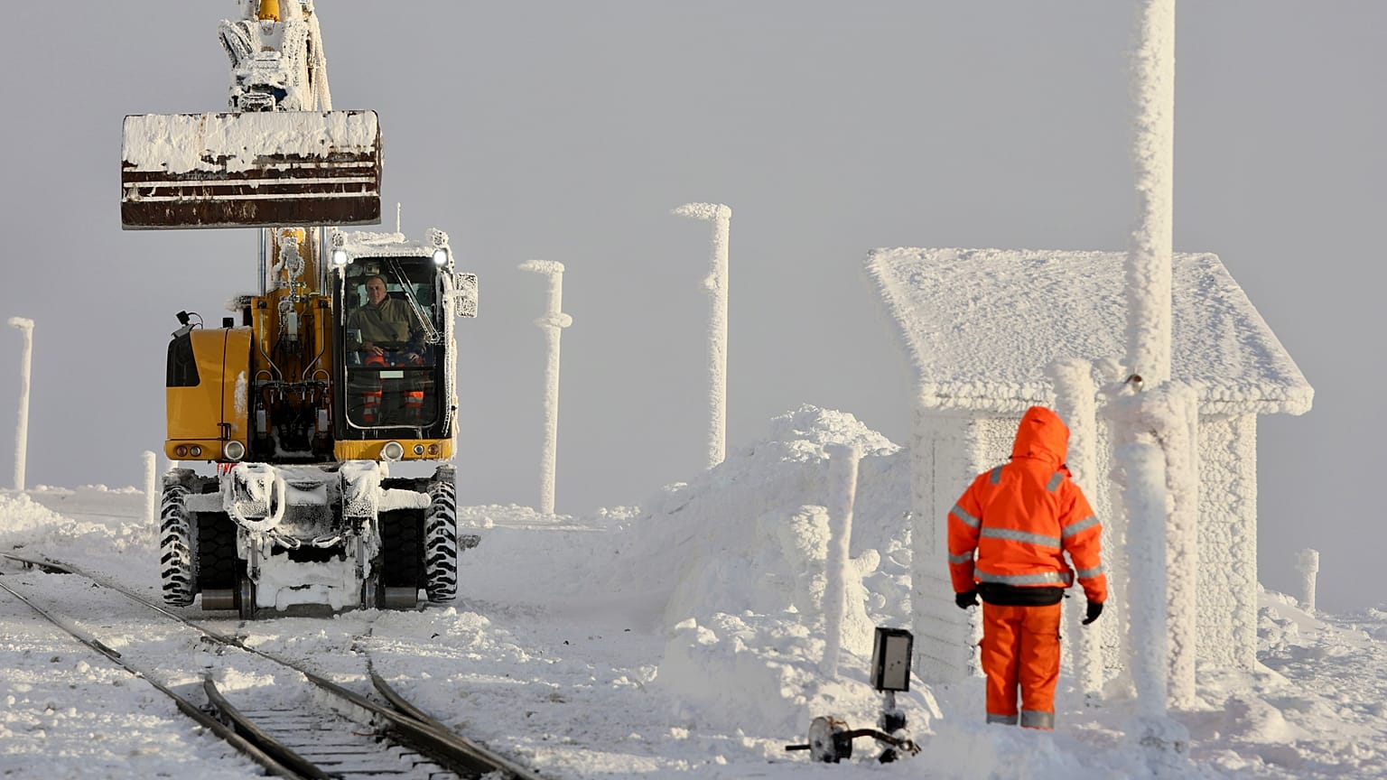 Funcionários limpam a neve dos carris na estação de Brocken em Schierke, Alemanha, domingo, 12 de janeiro de 2025