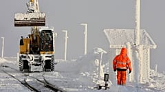 Funcionários limpam a neve dos carris na estação de Brocken em Schierke, Alemanha, domingo, 12 de janeiro de 2025