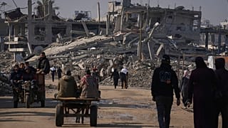 فایل - فلسطینیان روز شنبه 14 دسامبر 2024 آرد اهدای سازمان ملل را در خان یونس در مرکز نوار غزه حمل می کنند.