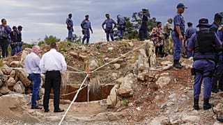 ARQUIVO: Agentes da polícia e pessoal de segurança junto às minas de Stilfontein, na África do Sul.