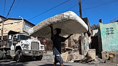 Port-au-Prince, Haiti'nin Poste Marchand mahallesinde çete şiddetinden kaçan mahalle sakinleri eşyalarını evlerinden çıkarıyor, 10 Aralık 2024, Salı.