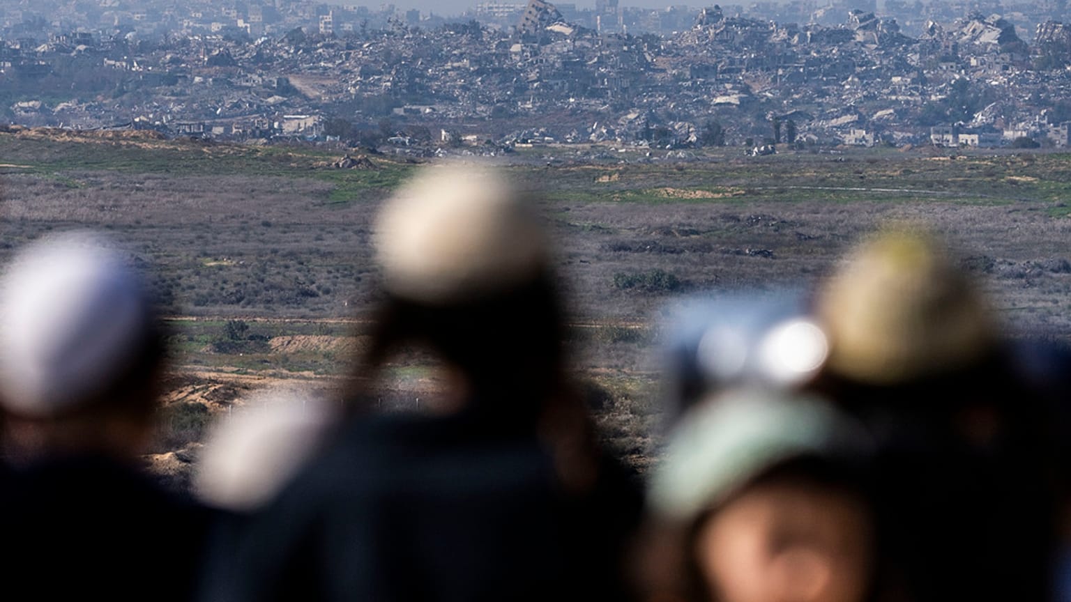 İsrail'in güneyindeki Sderot'taki bir tepede insanlar, işgal altındaki Gazze Şeridi'ni seyrediyor, 13 Ocak 2025