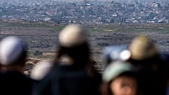 İsrail'in güneyindeki Sderot'taki bir tepede insanlar, işgal altındaki Gazze Şeridi'ni seyrediyor, 13 Ocak 2025