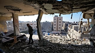 FILE: A Palestinian looks at a damaged residential building following an overnight Israeli strike in Deir al-Balah, Gaza Strip, 8 January 2025