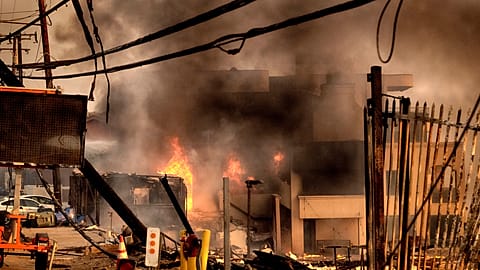Firefighters douse a burning home along the beach in Malibu, Calif. on Wednesday, Jan. 8, 2025.