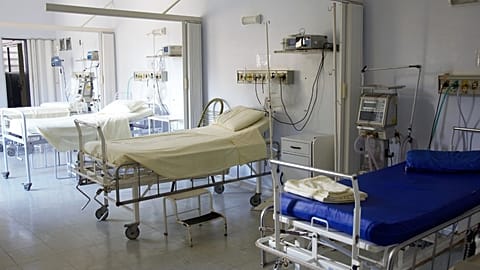 Empty hospital beds are shown.
