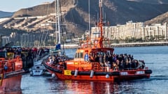 Migránsok érkeznek egy mentőhajó fedélzetére Gran Canaria szigetén, miután kimentették őket az Atlanti-óceánon 2020. október 17-én.