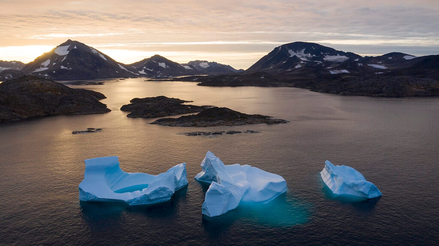  Grandi iceberg si allontanano al sorgere del sole vicino a Kulusuk, in Groenlandia.