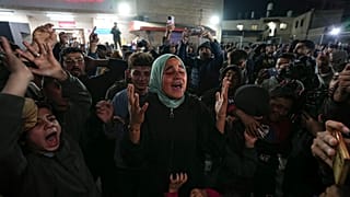 Palestinesi festeggiano l'annuncio di un accordo di cessate il fuoco tra Hamas e Israele a Deir al-Balah