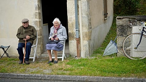 Two spectators wait for the peloton to pass during the eleventh stage of the Tour de France cycling race in Normandy, Wednesday, July 10, 2024.
