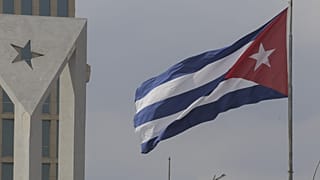 Uma bandeira cubana esvoaça ao vento no exterior da embaixada americana em Havana, Cuba, a 14 de janeiro de 2025.