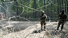 Polscy żołnierze pilnują metalowej bariery granicznej z Białorusią 