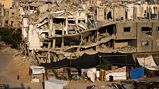 فلسطينيون يسيرون وسط الدمار الذي خلفته الغارات الجوية والبري الإسرائيلية في خان يونس جنوب قطاع غزة 7 كانون الثاني يناير 2025