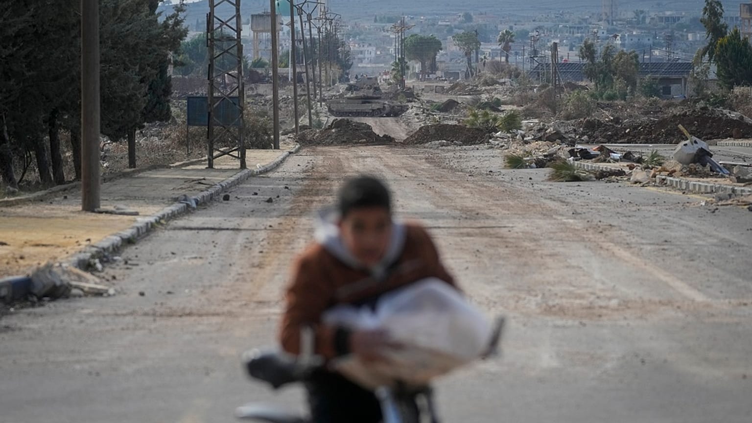 صبي يركب دراجته على طريق أغلقته مدرعات الجيش الإسرائيلي في أطراف بلدة القنيطرة بسوريا، الأحد 5 يناير 2025.