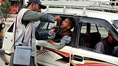 Bir sağlık çalışanı Ekim 2024'te Afganistan'ın Celalabad kentinde bir taksinin içinde bir çocuğa çocuk felci aşısı uyguluyor.