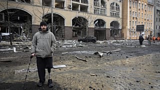 Um antigo soldado olha para os edifícios destruídos pelos recentes ataques russos em Kiev, 20 de dezembro de 2024