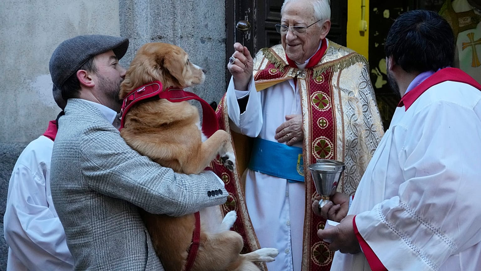 Le père Angel oint un chien lors de la fête de Saint Antoine